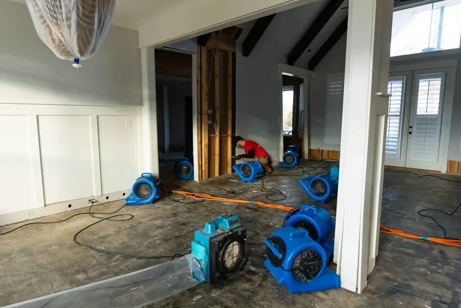 Air movers drying a soaked lower level inside an older St. Louis brick home